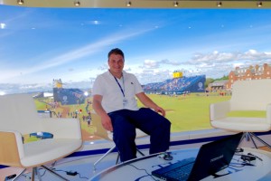 Jason Landau sitting in the presenter's chair in Sky Sports' on-course studio overlooking the 18th green at Royal Troon